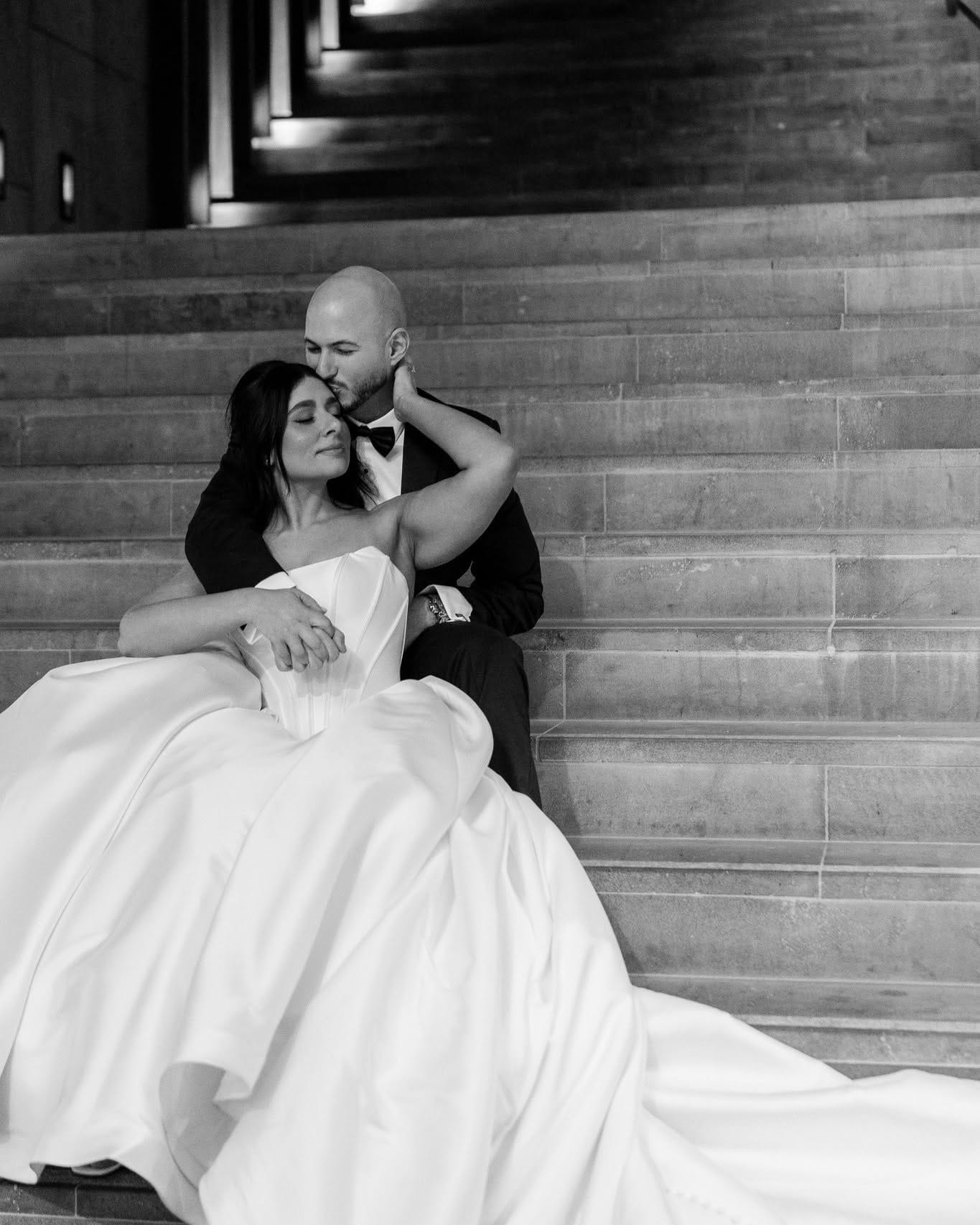 Bride seated as her groom kisses her head — Melbourne wedding photography