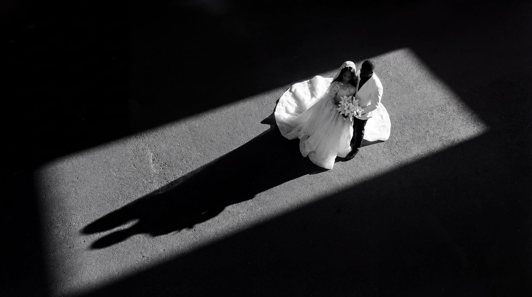 Dramatic black and white wedding portrait with light and shadow