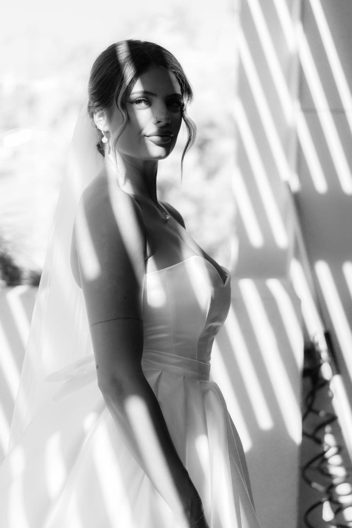 Black and white close portrait of a bride in dappled light