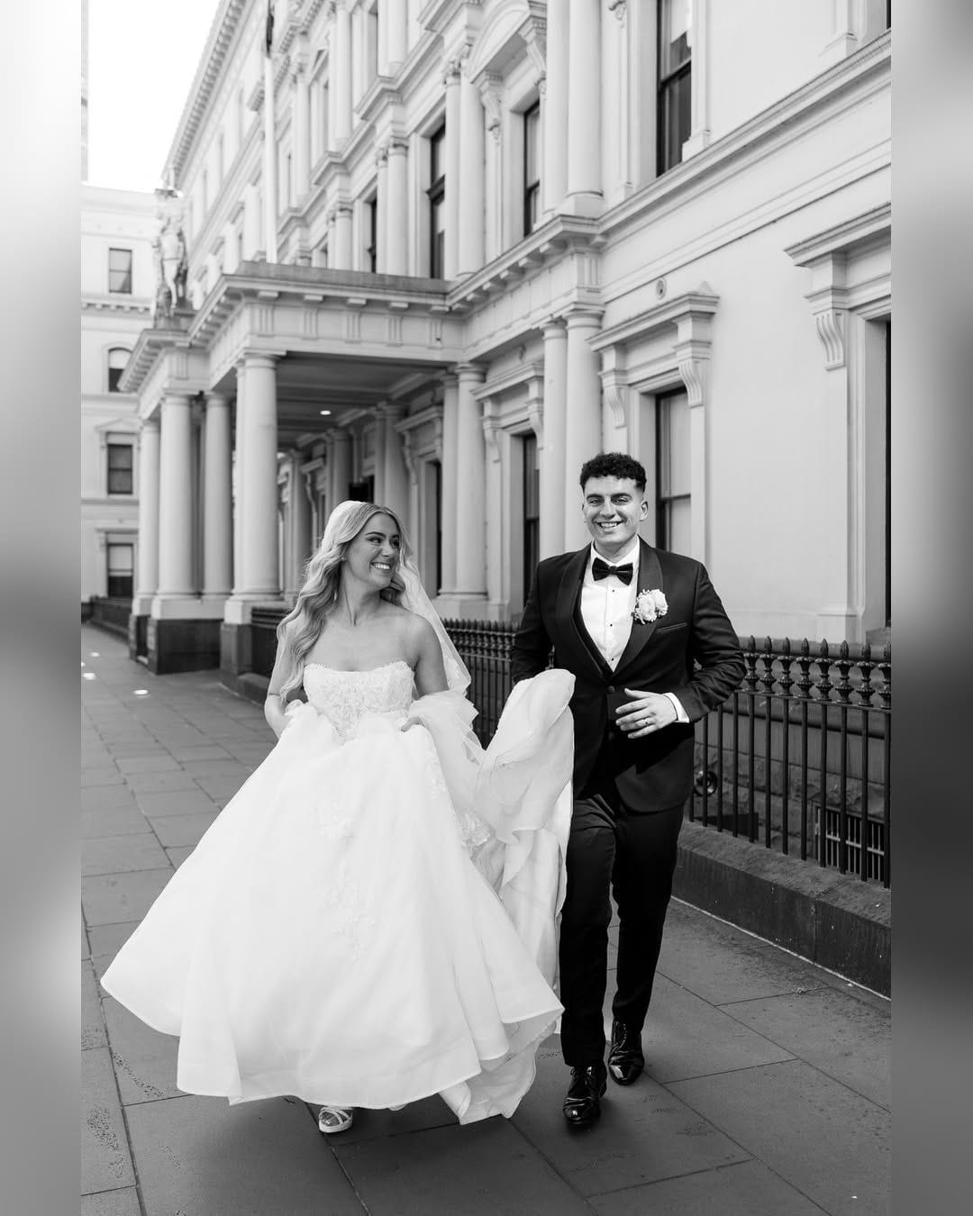 Black and white photo of a couple before a grand Melbourne building