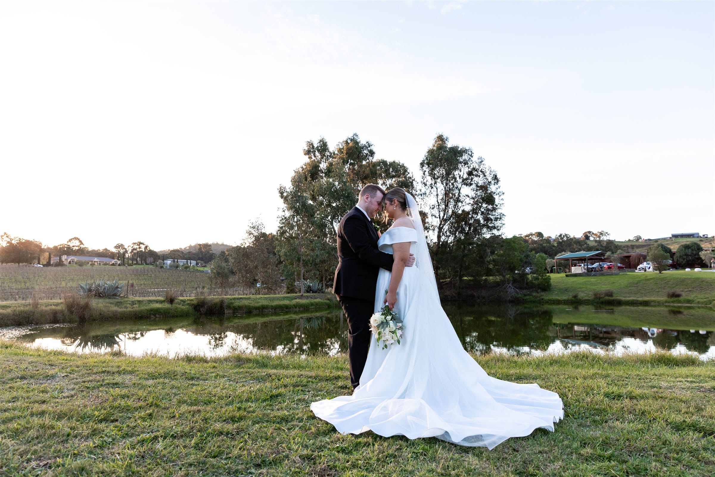 Newlyweds beside the water at Fergusson Winery in the Yarra Valley