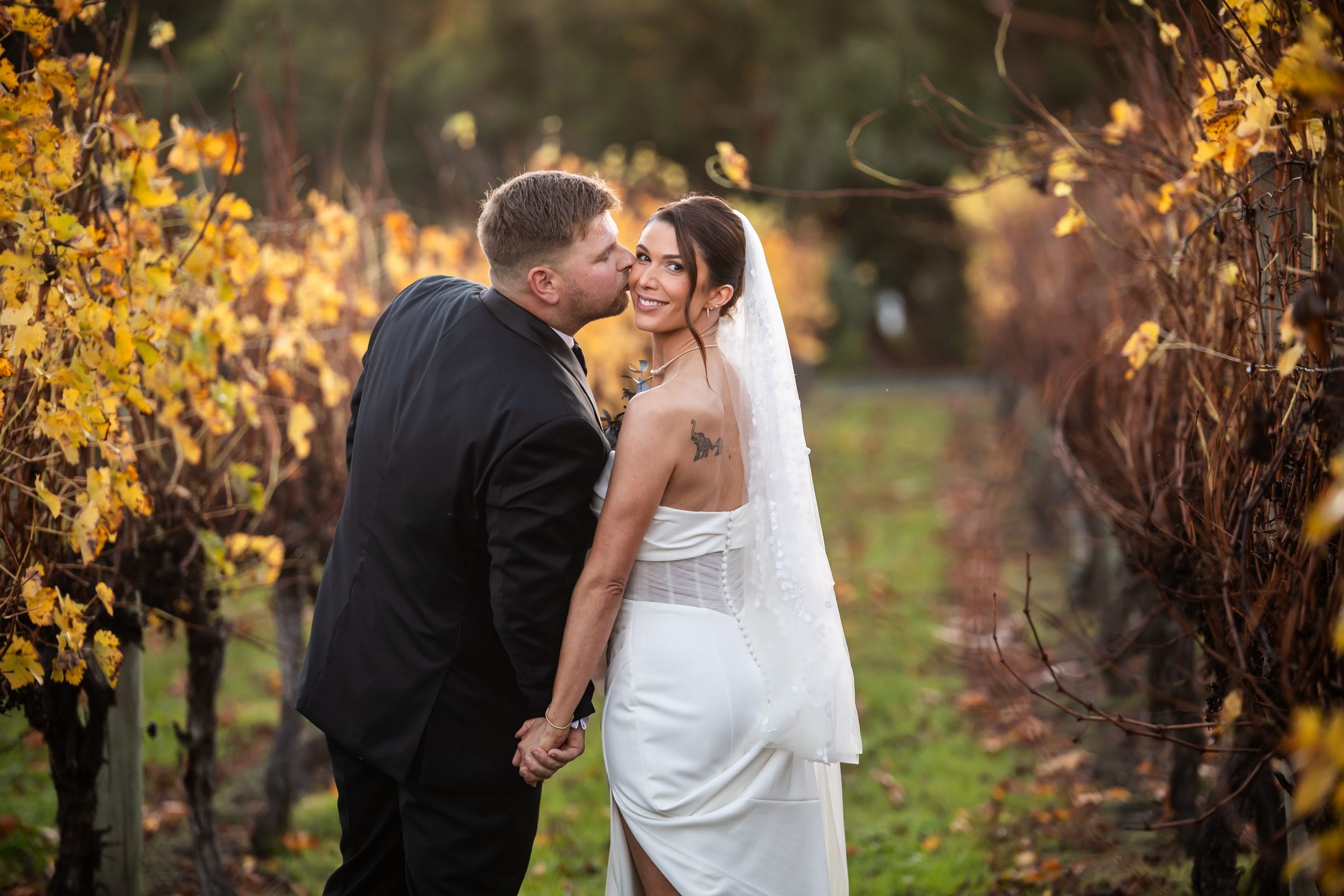 Close portrait of newlyweds among vineyard rows at Immerse Winery
