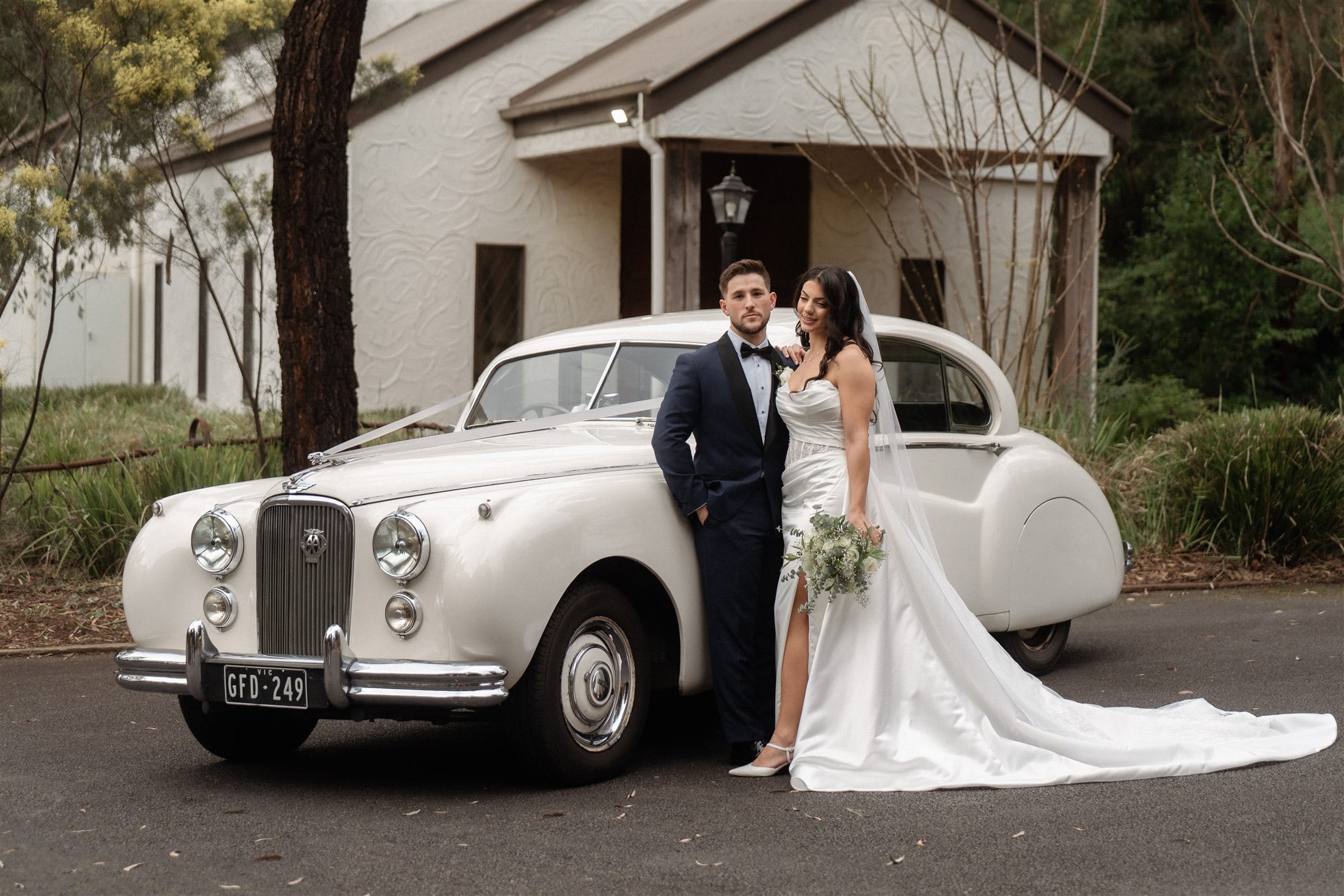 Afonso and Agnes beside a white vintage wedding car