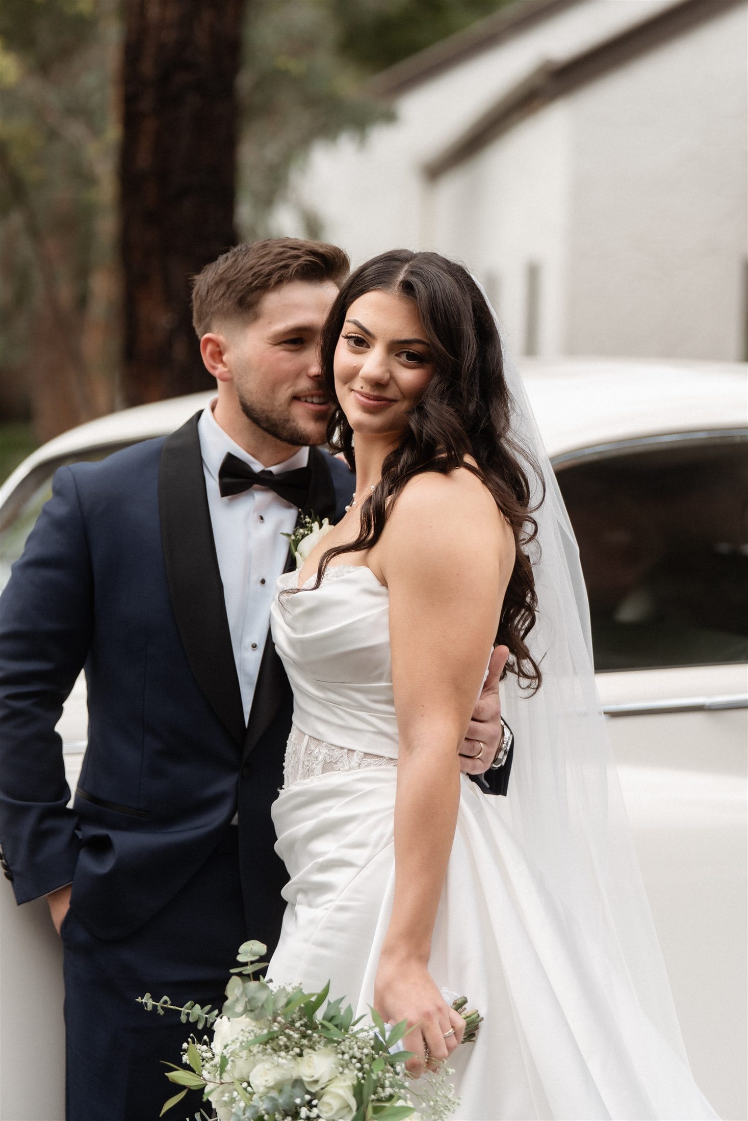 Afonso and Agnes close together beside the vintage car